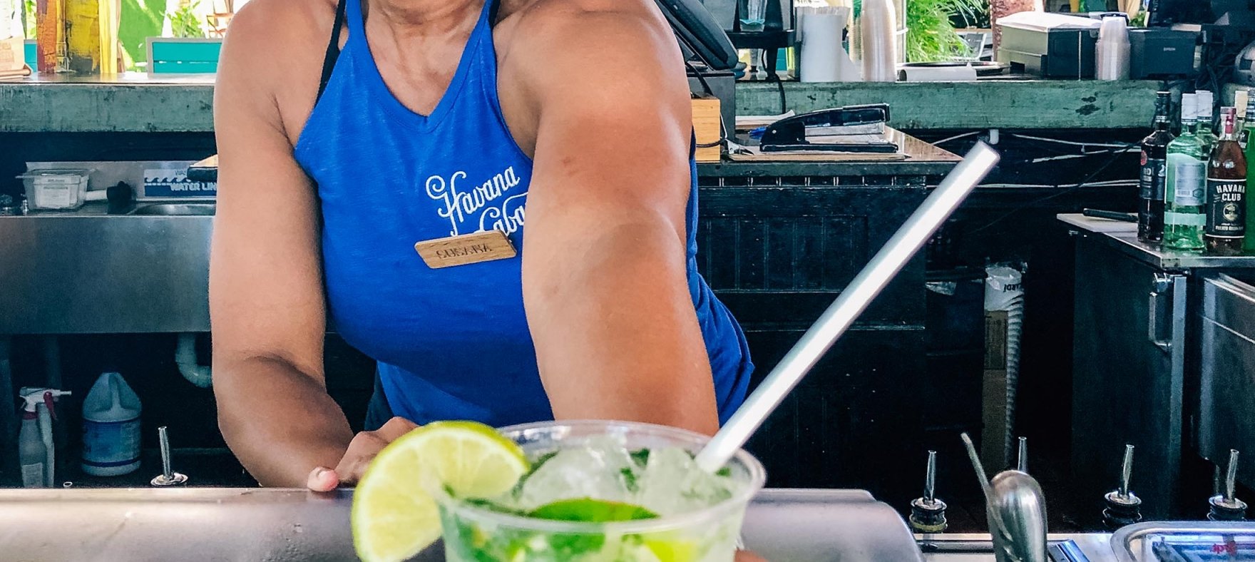 A woman placing a mojito on the counter