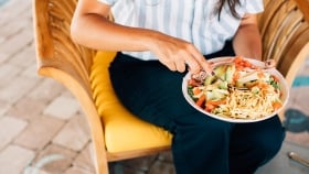 Woman sitting with an avocado and taco salad plate in her lap