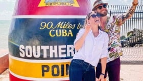 A couple take a selfie next to the Southernmost Point attraction in Key West, Florida.