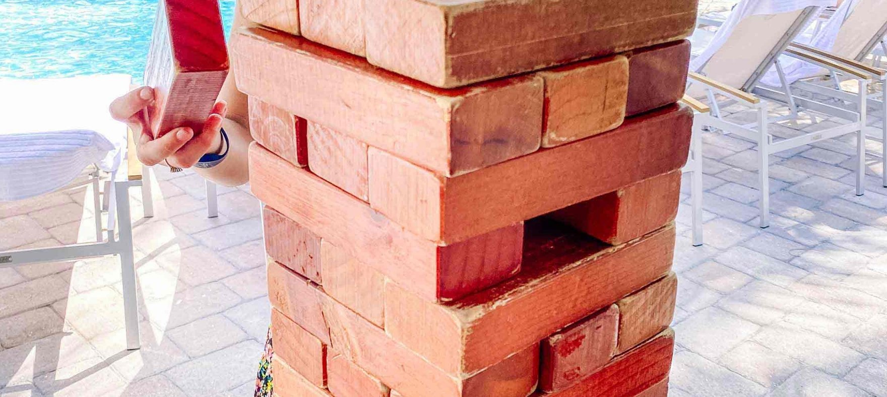 A close up of the mini brick structure with a woman holding a brick in the back