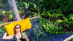 A woman resting in the woven hammock in the outdoors