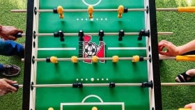 Two hands on the opposite side of the foosball table