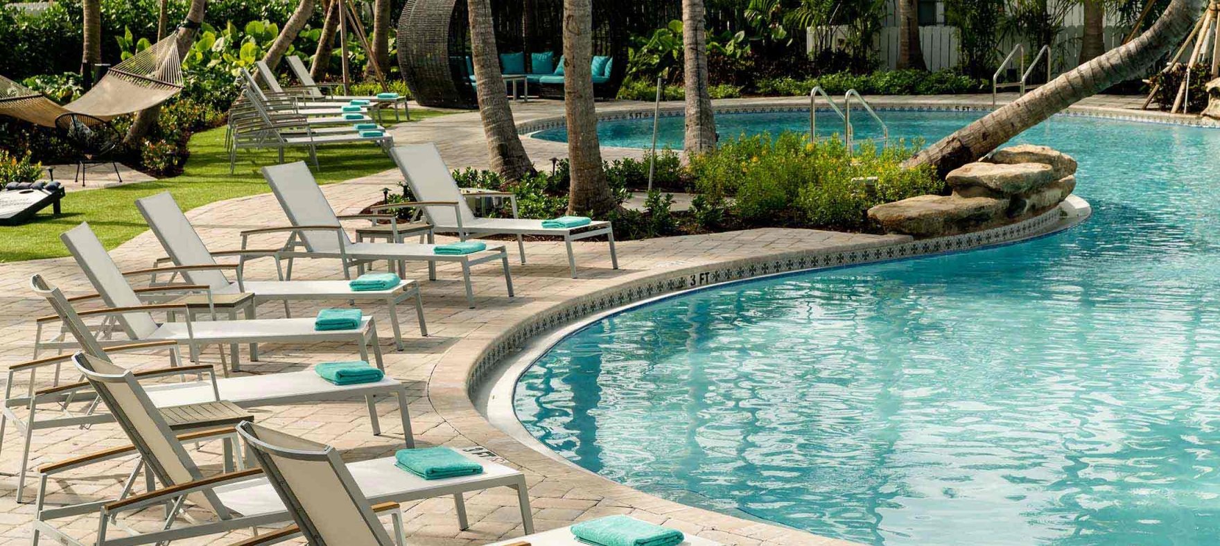 Lounge chairs set up in a curve next to the outdoor pool