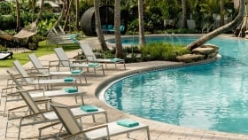Lounge chairs set up in a curve next to the outdoor pool