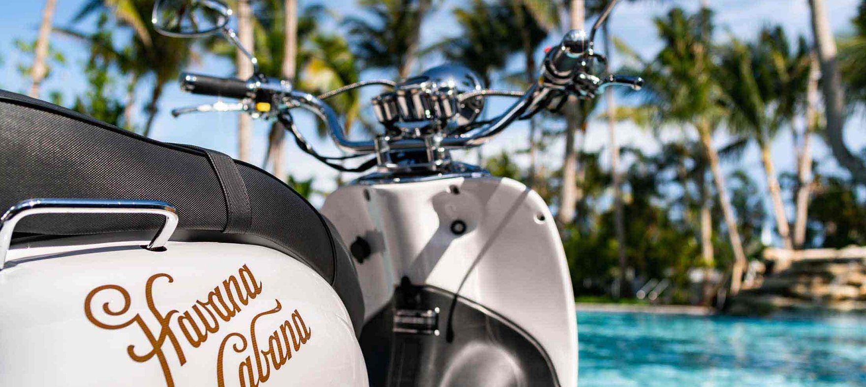 A close up of the Havana Cabano logo placed on the Vespa parked next to the outdoor pool
