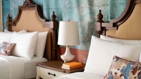 A close focus on the lamp placed on a shared bedside table in between the two queen beds