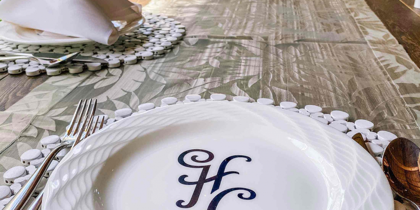HC initialled dining plates set on a placemat with cutleries and champagne flutes and napkins