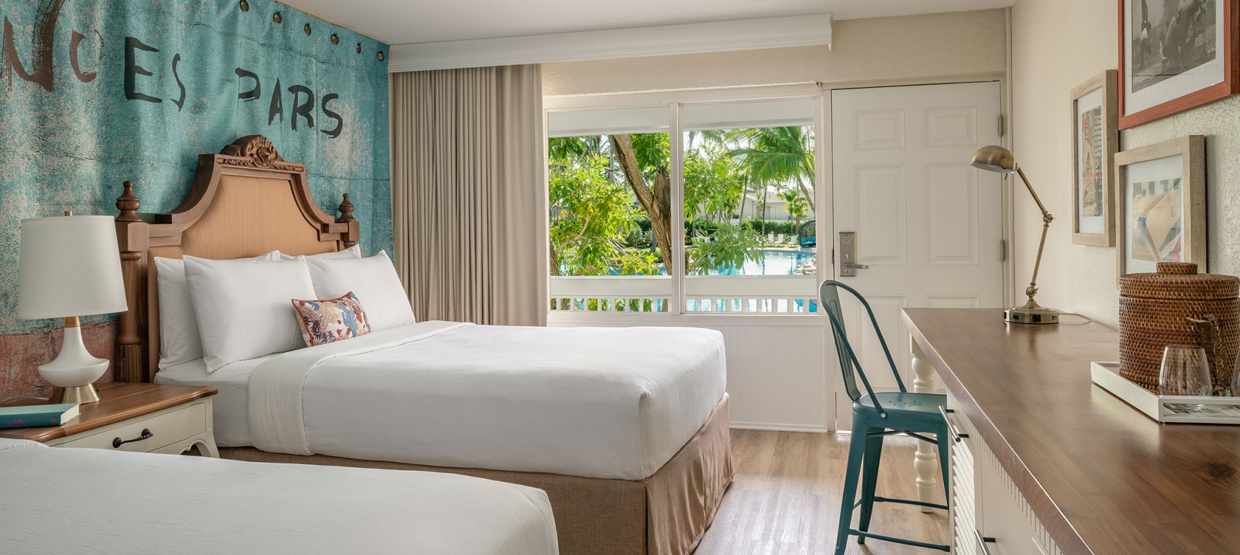 Interior view of the double Queen bedroom at Havana Cabana with a window overlooking the resort pool.