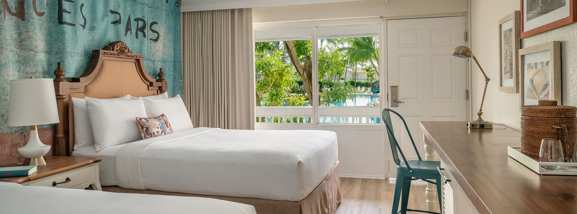 Interior view of the double Queen bedroom at Havana Cabana with a window overlooking the resort pool.