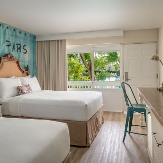 Interior view of the double Queen bedroom at Havana Cabana with a window overlooking the resort pool.