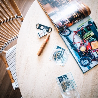 A top down view of a table with a magazine and cuban cigars.