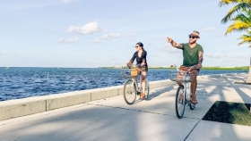 Two people riding bicycles along waterway