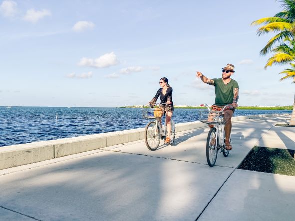 Two people riding bicycles along waterway