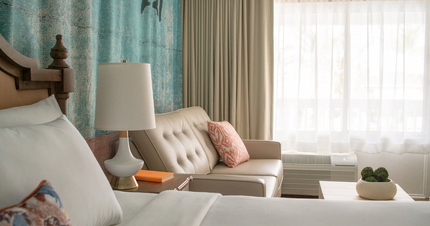 Close up view of a king bed and leather couch.