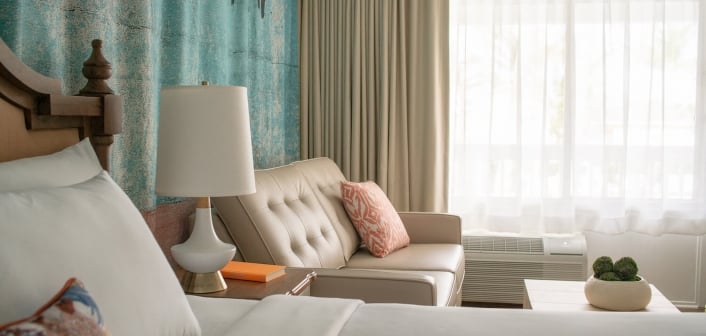 Close up view of a king bed and leather couch.