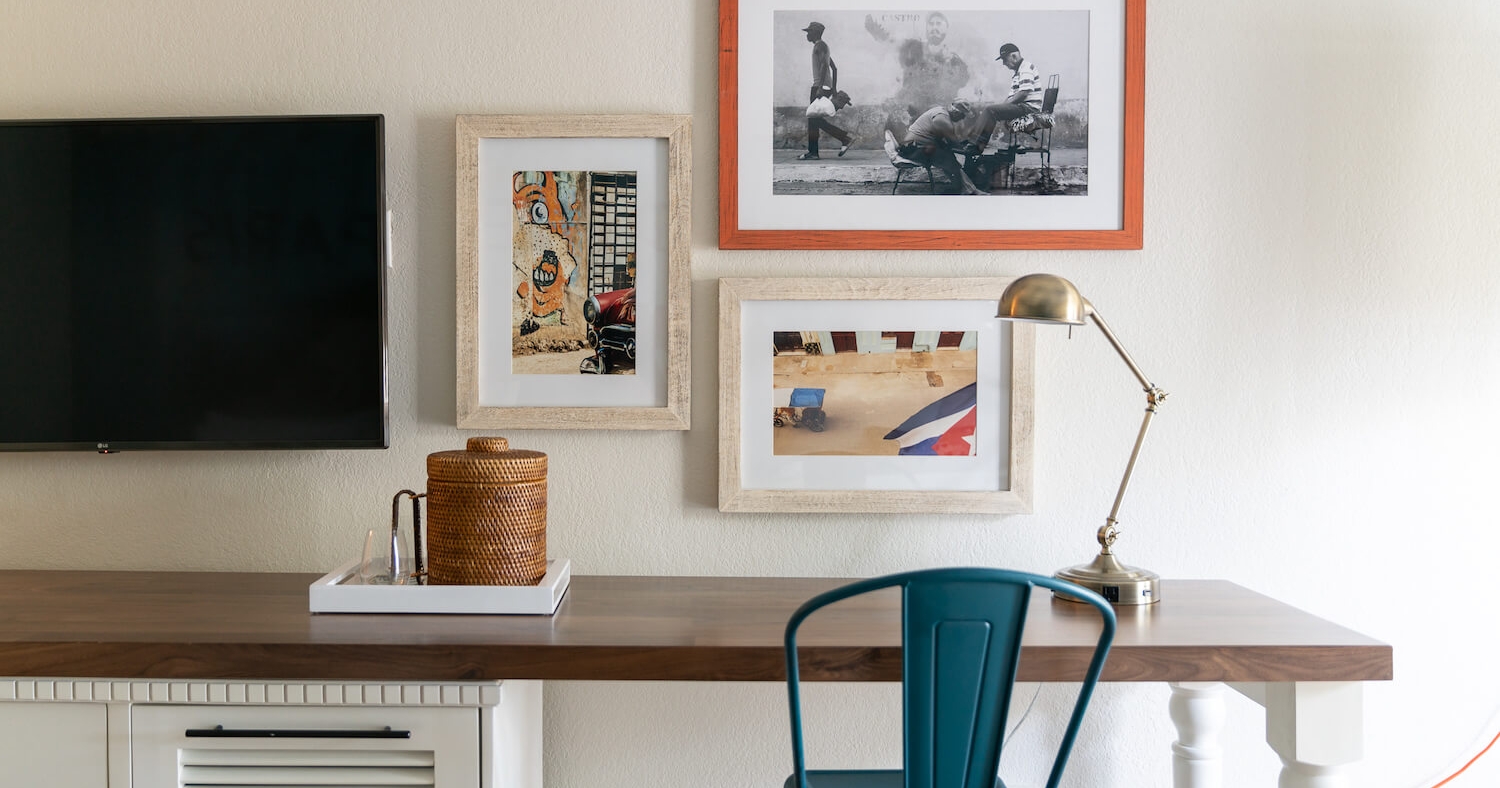 A wooden table, equipped with a metal blue chair and a gold desk lamp.