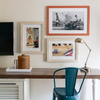 A wooden table, equipped with a metal blue chair and a gold desk lamp.