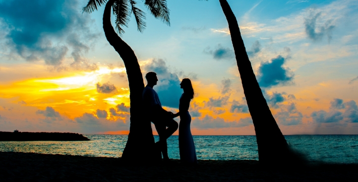 a couple on the beach during sunset