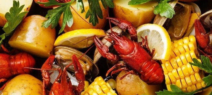 A dish with lobster, corn and lemons