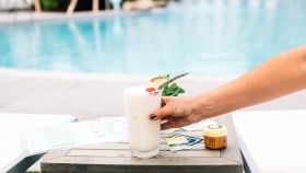a girl grabbing a drink by the pool